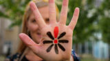 Hånd med Knæk Cancer logo på